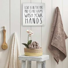 a bathroom with a towel rack, potted plant and towels