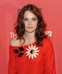 a woman with red hair wearing a red dress