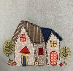 an embroidered house with trees and bushes on it