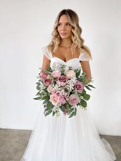 a woman in a wedding dress holding a bouquet