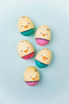 three eggs with painted faces on them sitting next to each other in the shape of a bird