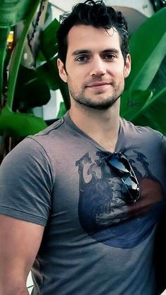 a man standing in front of a green plant