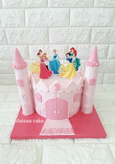 there is a cake with princesses on it and the castle has pink frosting