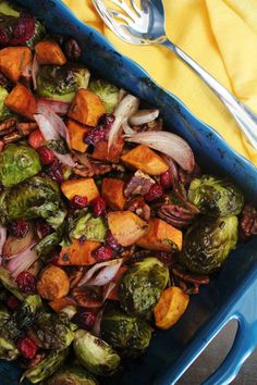 brussel sprouts, brussels sprouts and cranberries in a blue casserole dish