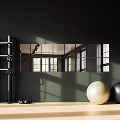 an empty room with exercise balls on the floor and a mirror in the wall behind it