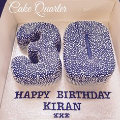 a blue and white cake with the number twenty five on it in a box that says happy birthday kiran