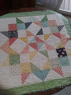 a quilted table topper on a wooden table