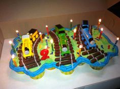 a birthday cake decorated with trains and candles