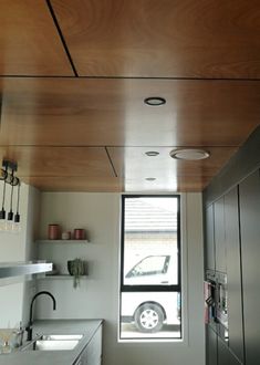 a kitchen with an open window and stainless steel appliances on the counter top, next to a sink