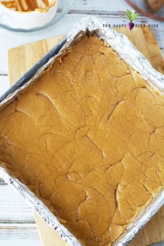 a pan filled with cake sitting on top of a wooden cutting board