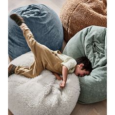 a young boy laying on top of a bean bag chair