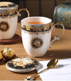 two tea cups with gold trimmings on them, one filled with chocolate and the other decorated with flowers