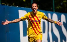 a soccer player with his arms wide open and hands out in the air while smiling