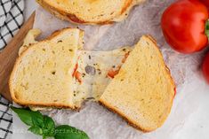 two pieces of bread with cheese and tomatoes on the side