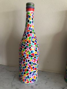 there is a bottle that has been decorated with different colors and shapes on the outside