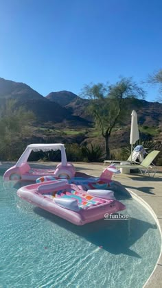 an inflatable pool with two lounge chairs next to it and mountains in the background