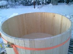 a large wooden barrel sitting on top of snow covered ground