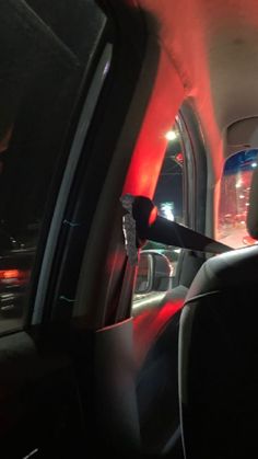 the interior of a car with red light coming from it's dash lights on