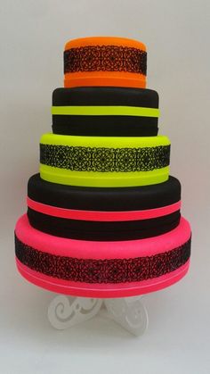 there is a multi layer cake with neon colors on it