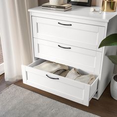 a white dresser with two drawers on top of it