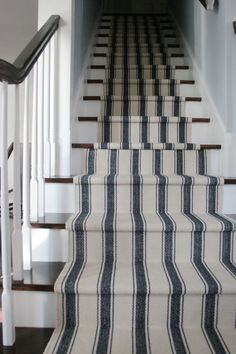 the stairs are lined with black and white striped carpet