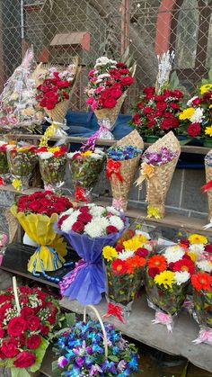 colorful flowers are arranged in baskets on display