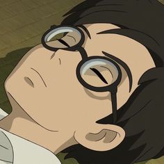 a man with glasses laying on the ground