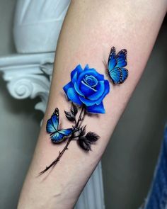 a blue rose and two butterflies on the arm