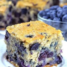 a close up of a plate of food with blueberries and cake in the background