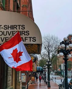 the canadian flag is flying in front of a clothing store