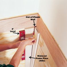 a person is working on the bottom part of a cabinet with two screwdrivers