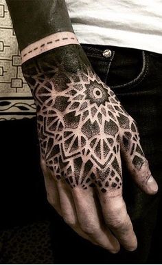 a man's hand with an intricate design on the left hand and his right hand is