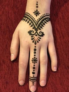 a woman's hand with a henna tattoo on it