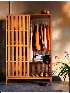 a wooden cabinet with clothes hanging on it