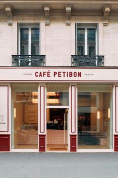 the storefront of cafe petitbon in paris, france is painted red and white