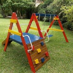 a colorful wooden swing set in the grass