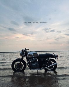 a motorcycle is parked on the beach in the water and it says, ride the tide of freedom