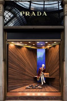 a window display with a mannequin sitting on a bench