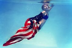 a woman in an american flag swims under water