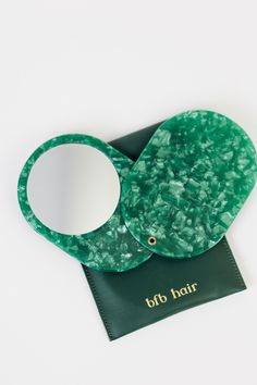 an elephant shaped mirror sitting on top of a piece of green paper with the words off to hair