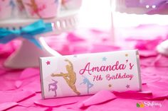 a pink and gold birthday party with cupcakes, cake and candy wrappers