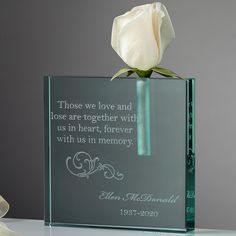 a glass block with a white rose in it and a poem written on the front