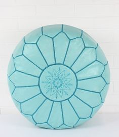 a blue round pillow sitting on top of a white table