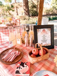 a picnic table with apples and drinks on it