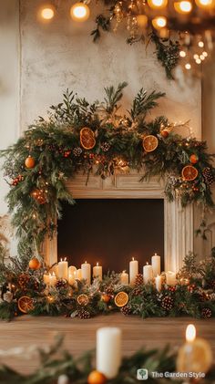 a mantel with candles, oranges and greenery on it in front of a fireplace