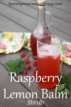 raspberry lemon balm shrub in front of a bottle and glass on a table