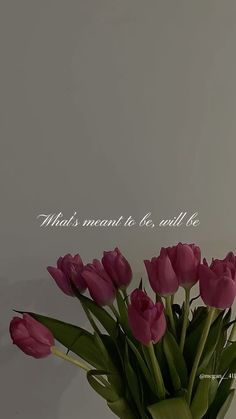 a vase filled with pink tulips sitting on top of a table next to a white wall