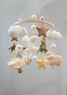 a mobile with sheeps and stars hanging from it's sides in the air