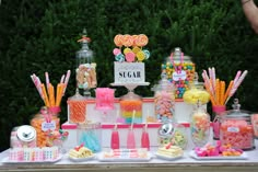 a candy bar with lots of candies and lollipops on the table