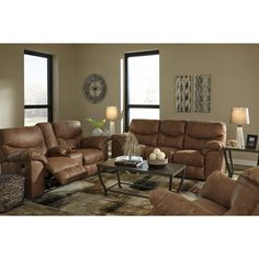 a living room filled with brown furniture and large windows